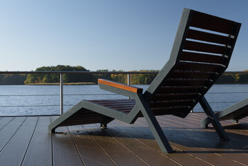 LANDSCAPE BY LAKE - Benches on the viewing and recreational platform in the sun rays
