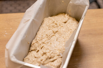 Close up shot of the bread loaf pan with the dough on the kitchen counter top. Food