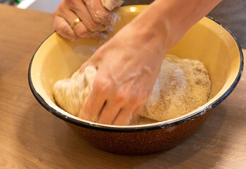 Woman kneads the dough in the bowl. Baking