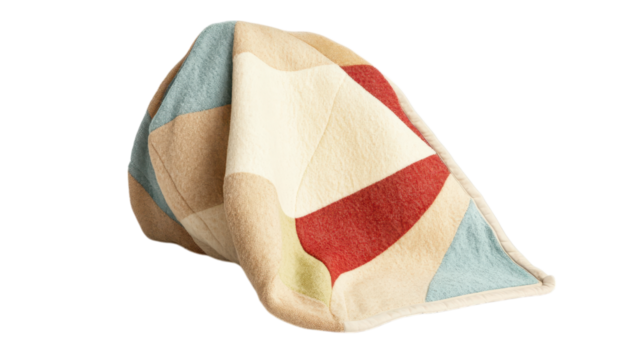 A colorful, patterned blanket draped artistically on a dark background.