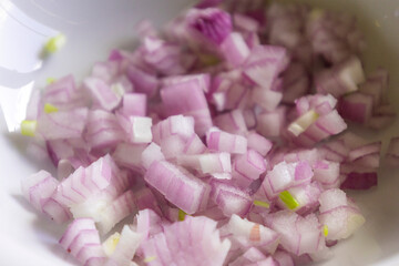 Finely Chopped Red Onion in a White Bowl Close-Up