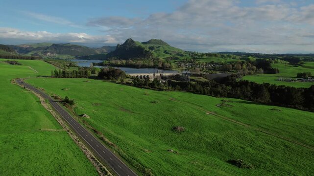 Aerial view of Waikato River and Whakamaru Dam, showcasing lush green landscapes and a hydroelectric power station. Captures New Zealand's natural beauty and renewable energy concepts.