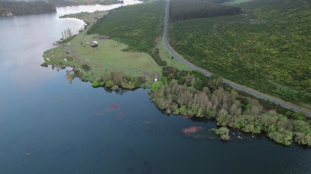 A tranquil aerial view of a reservoir near Whakamaru Dam, surrounded by forested hills and serene waters. Showcases New Zealand's natural landscapes and the concept of sustainable water management.