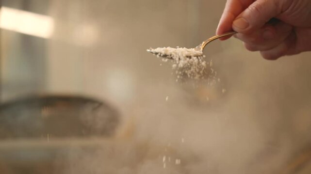 Sprinkle grated grana parmesan cheese in slow motion