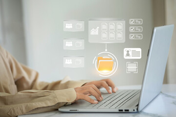 A person is typing on a laptop with a screen showing a file folder. The folder is labeled Work and...