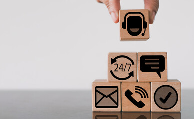 Contact customer support concept.,Hand holding wooden cube with call center icon with phone, email,...