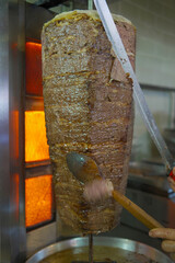 Close-up of a chef cutting meat with a doner knife for the traditional Turkish dish meat doner or shawarma. Street food concept. Meat doner in Istanbul Turkey.