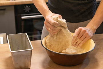 Woman kneads the dough in the bowl. Baking