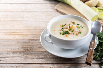 Cauliflower soup in bowl on wooden table. Copy space