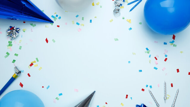Concept of festive birthday celebrations. Birthday attributes colorful balloons, party hats, candles, confetti