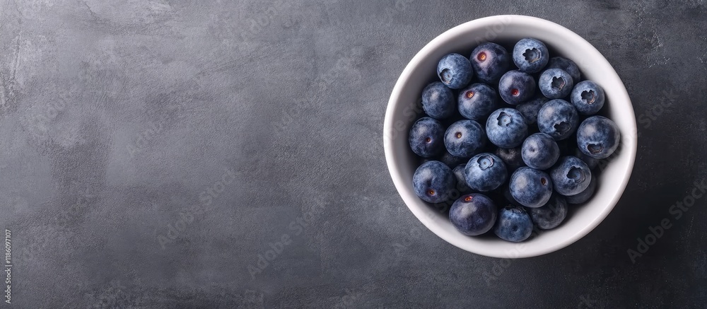 Poster fresh blueberries in a white bowl against a gray background top view soft focus. with copy space ima