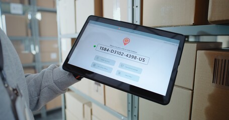 Inventory Manager Scans Code on Cardboard Box with Barcode Scanner, Checks Parcel Information. Tablet Computer Screen Shows Delivery Tracking System for Monitoring Package with Online Orders. Close Up