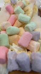 Sweet Belgian Waffles with multicolored marshmallow, banana, cream. An appetizing dessert. Close-up photo of food. Vertical format.