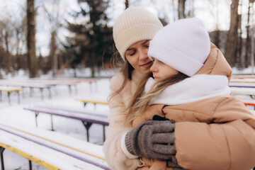 Fototapeta premium Happy mother and daughter on a walk in winter