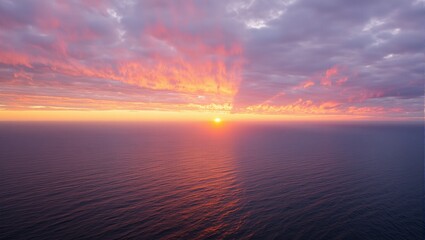 Fototapeta premium Sun setting over a golden ocean with colorful sky at twilight