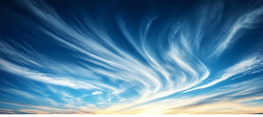 Vivid Blue Sky with Beautiful Swirling Wispy Clouds Background at Sunset, with Copyspace.