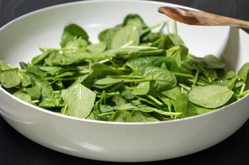 Fresh Spinach in a White Pan Ready to Cook Close-Up