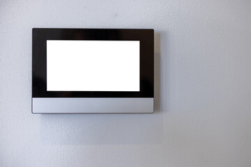 Smart home system control panel on a white wall of a living room or office. With a white screen as a blank background.