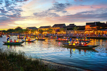 Hoi An, Vietnam at night and many tourists. Long-tail boats decorated with Vietnamese paper lanterns. A beautiful and important tourist attraction in Vietnam. Hoi An, Vietnam 