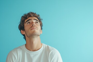 Obraz premium Young Man Contemplating Life's Mysteries Against a Vibrant Teal Background