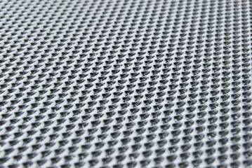A macro surface of perforated metal filter of a cooker hood close up