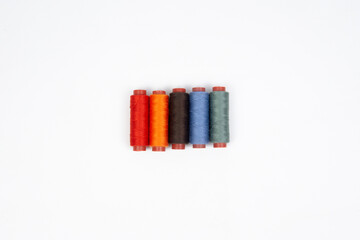 Set of different colorful sewing threads on white background