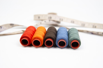 Set of different colorful sewing threads on white background