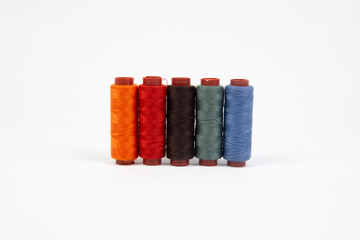 Set of different colorful sewing threads on white background