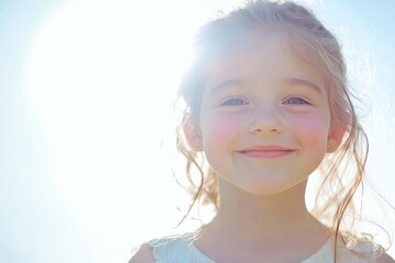 Joyful young girl smiling brightly against a vibrant summer sky with radiant sunlight, capturing the essence of freedom and happiness, ample space for text.