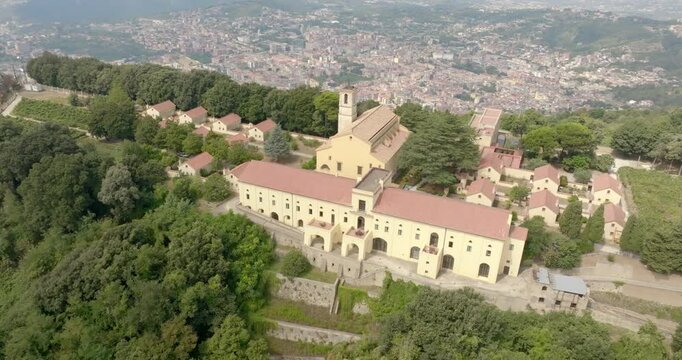 Aerial view of the Eremo dei Camaldoli in Naples, Italy. It's a ancient religious complex with a Catholic church and is located on top of a mountain. The hermitage overlooks the city in the background