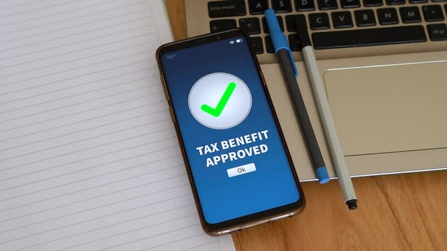Tax benefit approved notification on smart phone. Concept of having a cut in taxes and tax deduction.