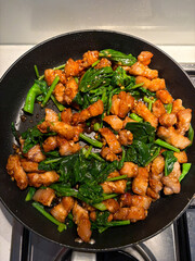 Pork and kai lan stir fry in the pan.