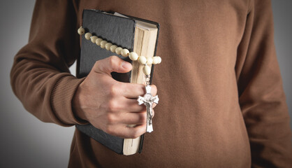 Man with a Holy Bible and rosary beads.