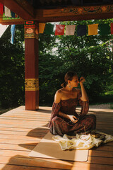 Woman practicing yoga and meditation in a Buddhist temple, relaxed with closed eyes. Mindful...