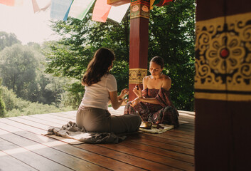 Close up of female mentor and student before Mindful meditation and yoga in the gazebo....
