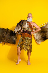 Obraz premium Vertical full length photo of confident barbarian guy dressed leopard fur hunting animals blank space isolated yellow color background