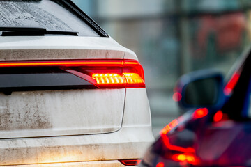 Dirty winter mud covered car back tail light braking