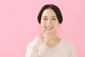 ピンク背景　笑顔の女性　白い歯
