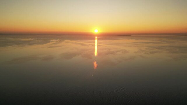 drone smooth video of bright golden hour sunset at the Italian lake Garda Lake 