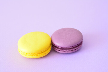 a yellow and a purple macaroons isolated on the lilac background copy space  