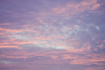 Sunset in the sky in pastel colors. Purple and pink sky with clouds in the evening. Nature background.
