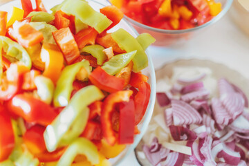 Cut vegetables ready to be cooked or fried. Chopped vegetables on a cutting board. chopped bell pepper, tomatoes and onions. Top view.