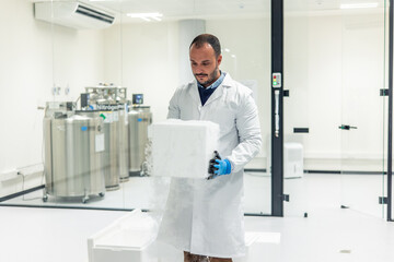 Naklejka premium Scientist carrying block of dry ice in laboratory near cryogenic tanks