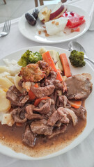Beef stew with mashed potatoes, vegetables and fried dumplings served with fruit salad in an egyptian sataya resort