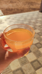 Tourist holding glass of fresh orange juice in marsa alam, egypt