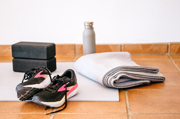 Post run recovery gear setup: running shoes, yoga blocks, water bottle, blanket