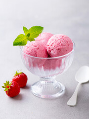 Strawberry Ice Cream in a glass bowl on grey background. Close up.