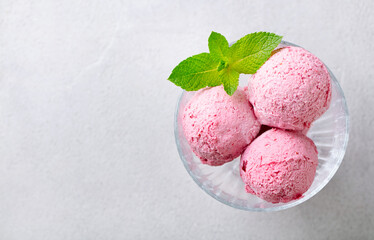 Strawberry Ice Cream in a glass bowl on grey background. Copy space. Top view.