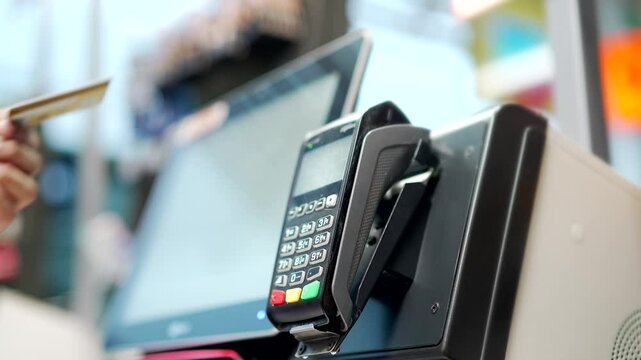 Close up man At Counter Buy electronic payment supermarket by credit card close-up. Male hand pay for purchases in stores Contactless NFC pos Terminal Closeup card reader at cashless wallet