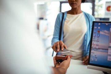 Woman making contactless payment at pharmacy counter